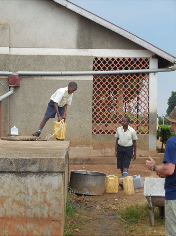 Students draw water from the large underground tank at St. Kizito for use at the school using 20 liter Jerry Cans. Improvements to the St. Kizito rain harvesting system will provide an additional 2.9 million liters annually to the school. When the overall cost of the system is calculated, assuming a 10-year life and a 5 percent annual maintenance cost along with the $27,000 capitol cost, the school saves 35 to 235 Uganda Shillings per Jerry Can (20 liters) of water compared to purchasing water at a hand pump during the dry season. 