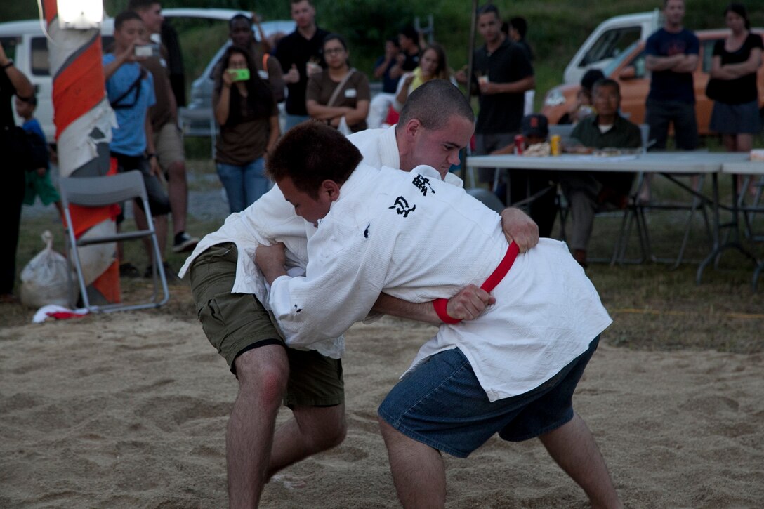 Lance Cpl. Tom M. Enright, left, attempts to topple Yoshiya Sakumoto May 31, 2014 during the annual Henoko Okinawa-Style Sumo Tournament at Mae-No-Hama field in Henoko. Okinawa-style sumo wrestling, also known as kakuriki, is a combination of western wrestling and traditional Japanese sumo and judo, according to Fumio Iha, the community relations specialist with Camp Schwab, Marine Corps Base Camp Smedley D. Butler, Marine Corps Installations Pacific. Enright is a Deadwood, S.D., native and electro-optical ordnance repairer with Combat Assault Battalion, 3rd Marine Division, III Marine Expeditionary Force.