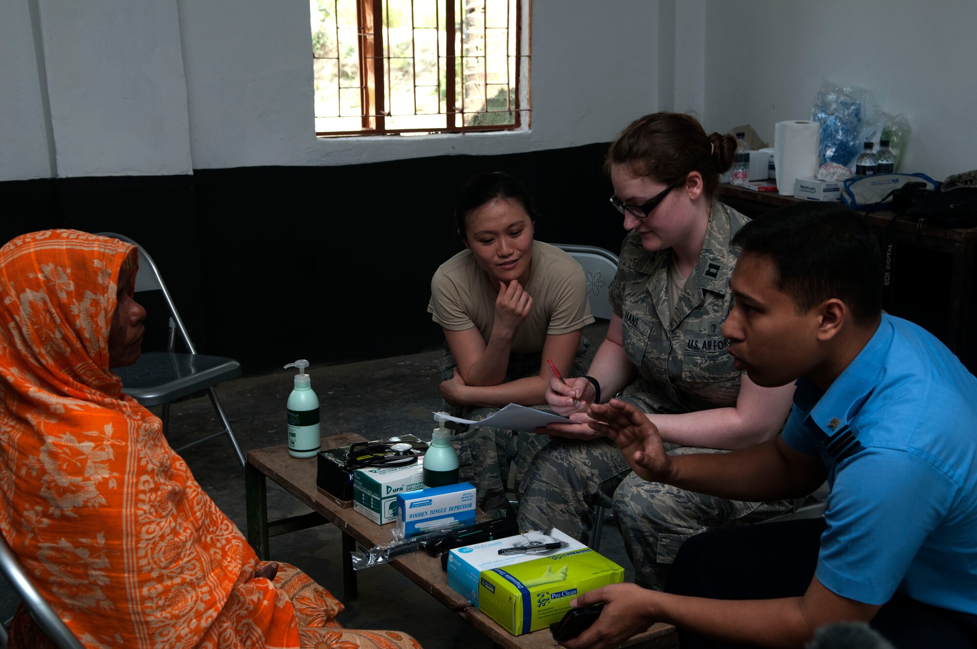 U.S. Air Force Capt. Nicole Hans, a family practice doctor with the 354th Medical Operations Squadron from Eielson Air Force Base, Alaska, and Master Sgt. Chau Huynh, a dental technician with the 142nd Medical Group from Portland Air National Guard Base, Oregon, talk to a patient using a translator June 1, 2013 during Operation Pacific Angel near Rangpur, Bangladesh a part of Operation Pacific Angel. OPA is a joint and combined humanitarian medical and engineering mission with U.S., Sri Lanka and Bangladesh military forces, the United States Agency for International Development, and the Bangladesh Ministry of Health. (U.S. Air Force photo/ Capt. Cait Suttie)