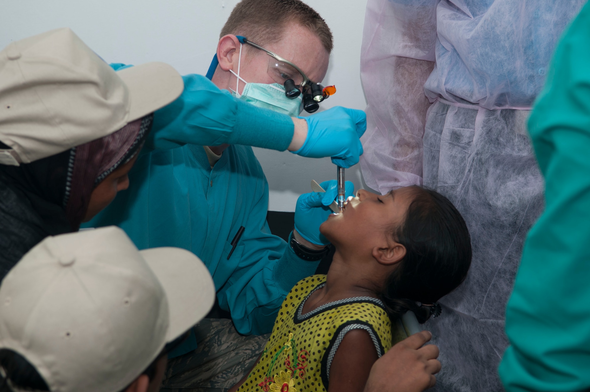 U.S. Air Force Capt. David Chesser, a dentist with the 35th Dental Squadron from Misawa Air Base, Japan, extracts a tooth from a nine-year-old girl June 1, 2013 during Operation Pacific Angel in Rangpur, Bangladesh. Dental care is one of three services offered during the health services portion of the operation. Doctors in family practice, dental and optometry saw 615 patients during the first day of treatment. (U.S. Air Force photo/ Capt. Cait Suttie)