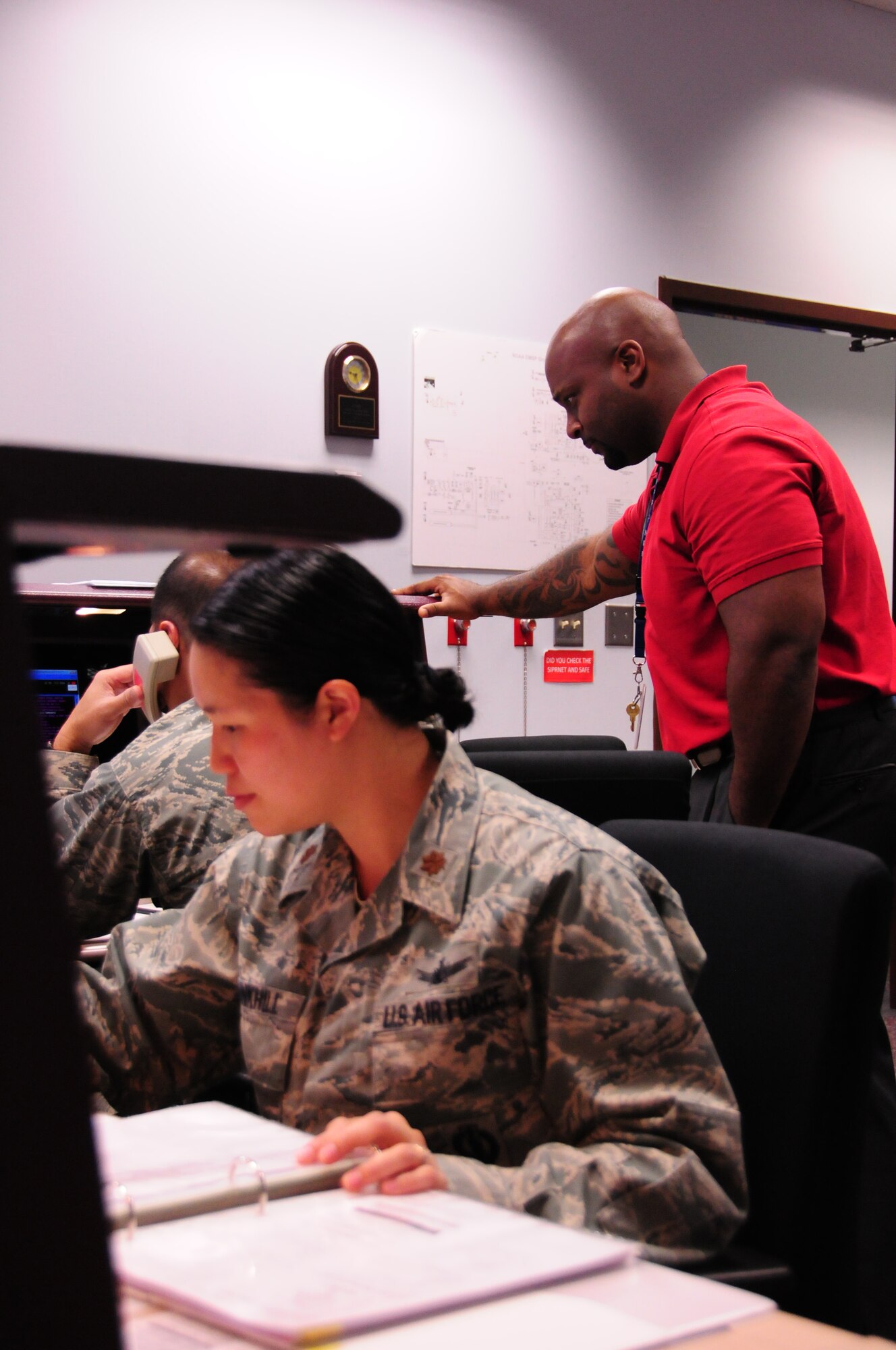 Air Force Reserve Maj. Carleen Trunkhill, 6th Space Operations Squadron Chief of standardization and evaluation, Capt. Shawn Marcello, 6th SOPS satellite systems operator, and Julian Dashield, National Oceanic and Atmospheric Administration engineer, perform a satellite contact to retrieve environmental monitoring data for delivery to the Air Force Weather Agency and Fleet Numerical Meteorology and Oceanography Center during an annual Continuity of Operations Plan at Schriever AFB, Colo.  The COOP exercise provides military and civilian operators a chance to exchange new ideas, techniques and procedures, and enhance operations at facilities in Suitland, Md., and Schriever AFB. (U.S. Air Force photo/Tech. Sgt. Jeff Fitzmorris)