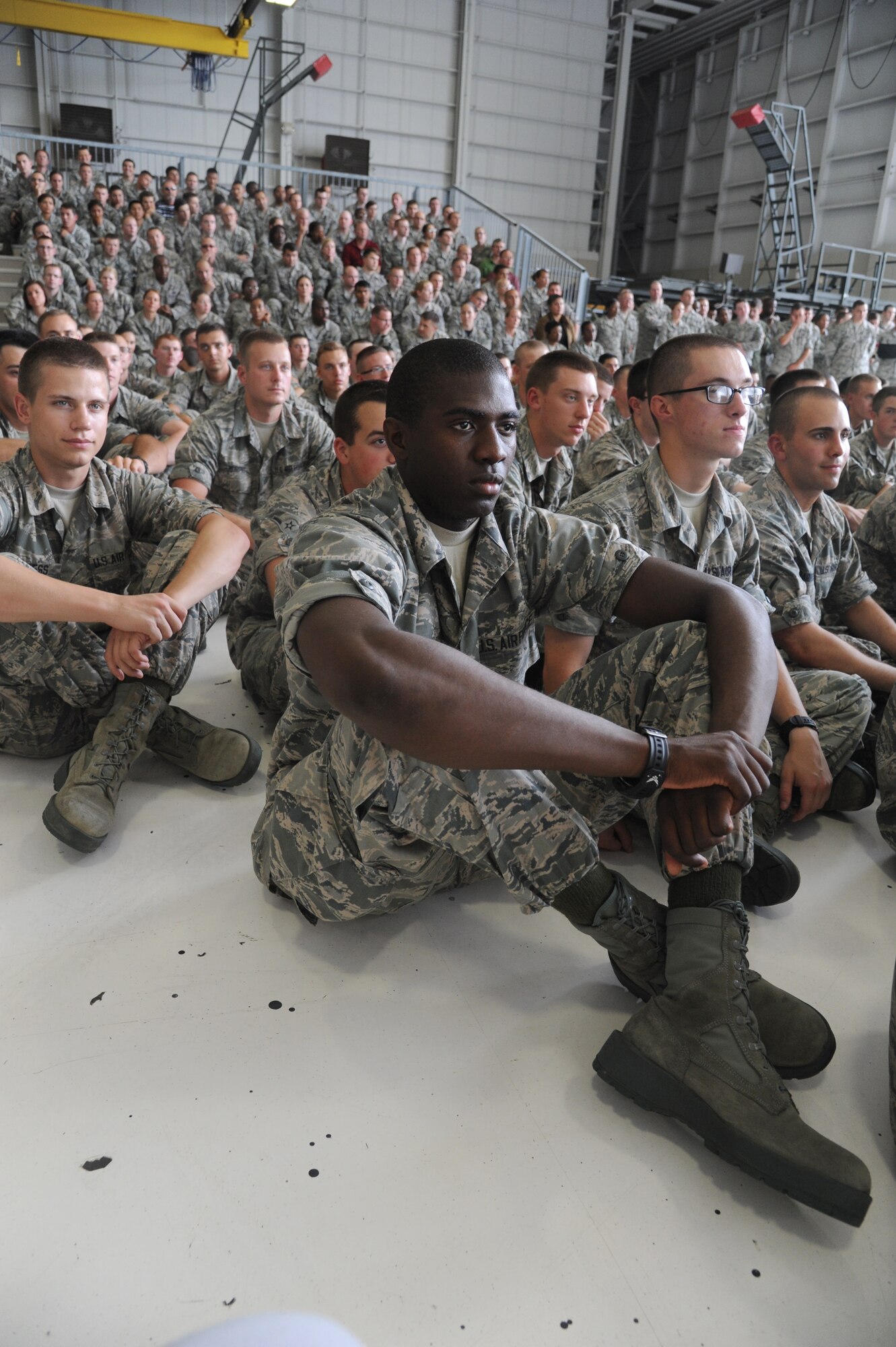 Airman Basic Cameron Turner, 336th Training Squadron, sits with fellow Airmen as they listen to the  Secretary of the Air Force, Deborah Lee James, speak to base personnel during an All Call following a base orientation visit by James May 30, 2014, at the dual bay hangar at Keesler Air Force Base, Miss.  James also toured the Levitow Training Support Facility and the 403rd Wing.  (U.S. Air Force photo by Kemberly Groue)