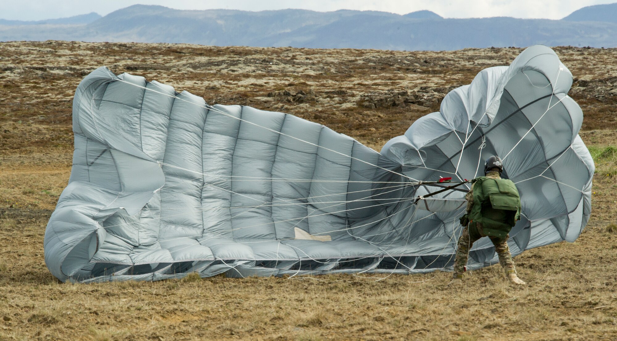 KEFLAVIK, Iceland -- A pararescueman deployed for Icelandic Air Policing with the 48th Air Expeditionary Group gathers his parachute after jump training near Keflavik International Airport May 22, 2014. The Pararescueman is deployed from the 31st Rescue Squadron to support the NATO mission of ensuring Iceland’s air sovereignty. (U.S. Air Force photo/Tech. Sgt. Benjamin Wilson)(Released)