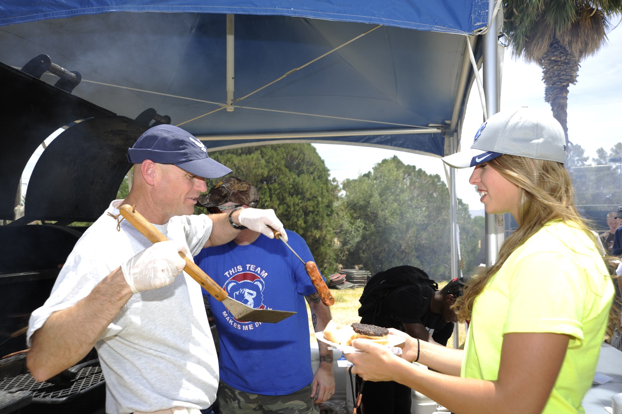 U.S. Air Force Master Sgt. Kyle Capehart, 355th Security Forces Squadron assistant first sergeant, serves a Desert Lightning Team member during a Comprehensive Airman Fitness Day at Davis-Monthan Air Force Base, Ariz., June 2, 2014. The base held events to include a pancake social, dodgeball tournament and a burger burn. (U.S. Air Force photo by Airman 1st Class Betty R. Chevalier/Released)