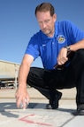 Geren Fawver, 12th Operations Support Squadron airfield manager, marks the location of a damaged area on the taxiway May 16 during his morning flightline inspection at Joint Base San Antonio-Randolph. (U.S. Air Force photo by Johnny Saldivar)

