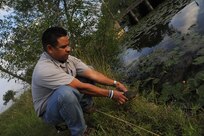 Michael Pacheco, 12th Flying Training Wing wildlife biologist and airport operations, helps a turtle return to a nearby pond after spotting him close to the flightline May 21 at Joint Base San Antonio-Randolph. (U.S. Air Force photo by Airman 1st Class Kenna Jackson)


