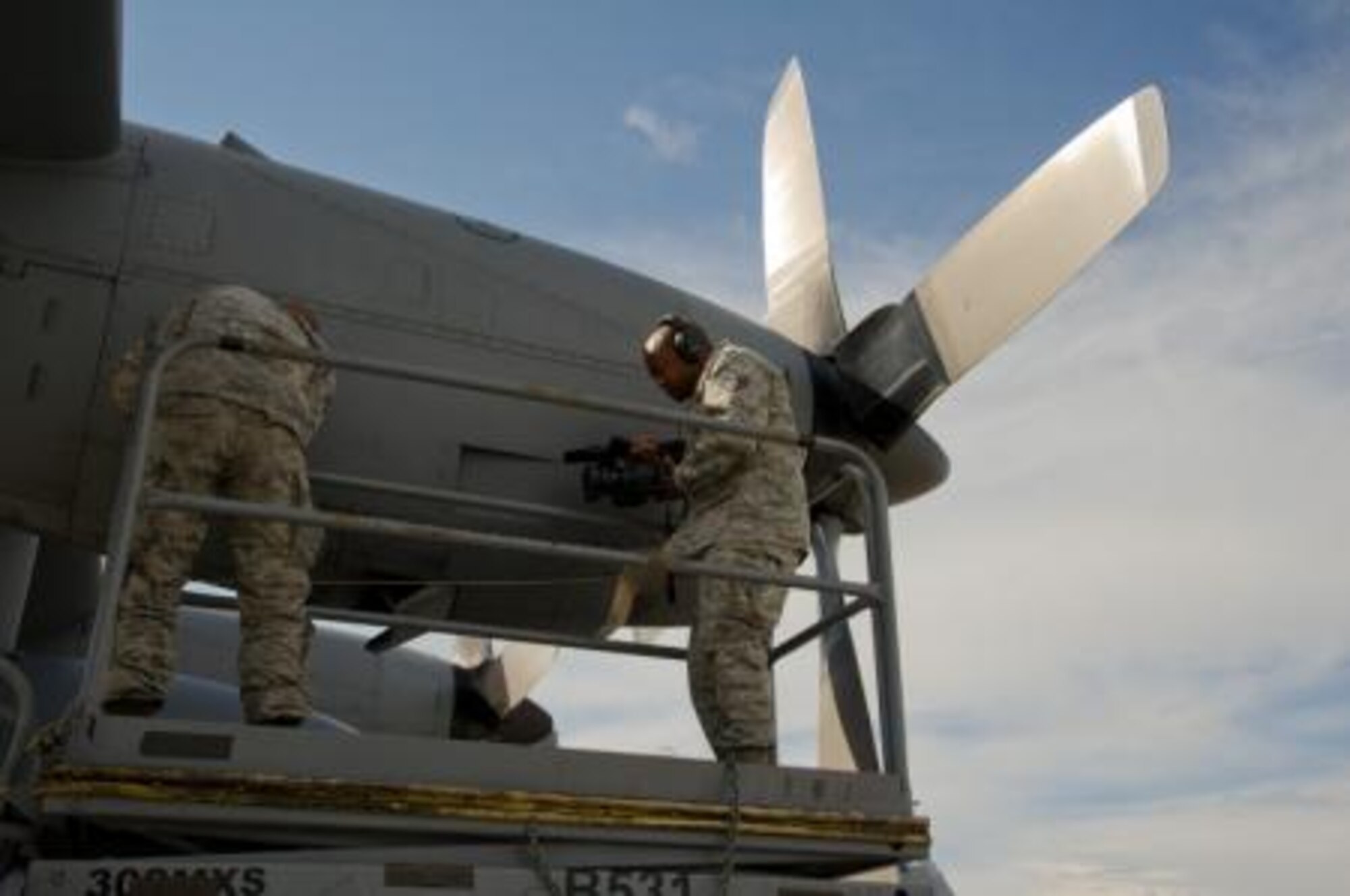 U.S. Air Force Staff Sgt. James Jackson, broadcast journalist, 4th Combat Camera Squadron, March Air Reserve Base, Calif., documents Staff Sgt. Andrew Schmelzer, aerospace propulsion, 302nd Airlift Wing, Peterson Air Force Base, Colo., working on a C-130 Hercules aircraft during Maple Flag in Edmonton/Cold Lake, Alberta, Canada, May 26, 2014. Maple Flag is an international exercise designed to enhance the interoperability of C-130 aircrews, maintainers and support specialists in a simulated combat environment. (U.S. Air Force photo by Tech. Sgt. Matthew Smith/Released)