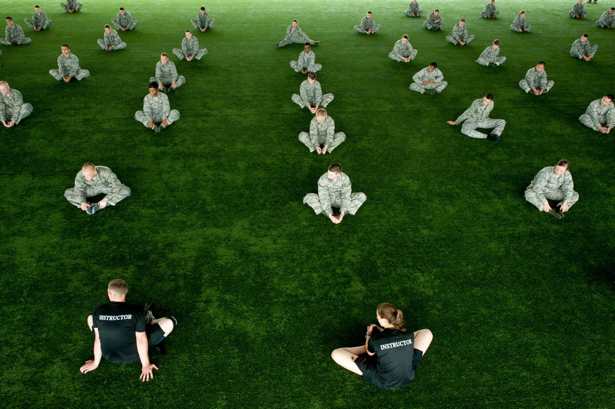 Cadets from the Air Force Reserve Officer Training Corps accomplish group stretches, led by student instructors as a part of combatives training at Maxwell Air Force Base, May 29, 2014.The training is part of a two-week summer program meant to instill the warrior ethos and provide field training to AFROTC cadets in their junior year at a program in college. (U.S. Air Force Photo by Staff Sgt. Gregory Brook)