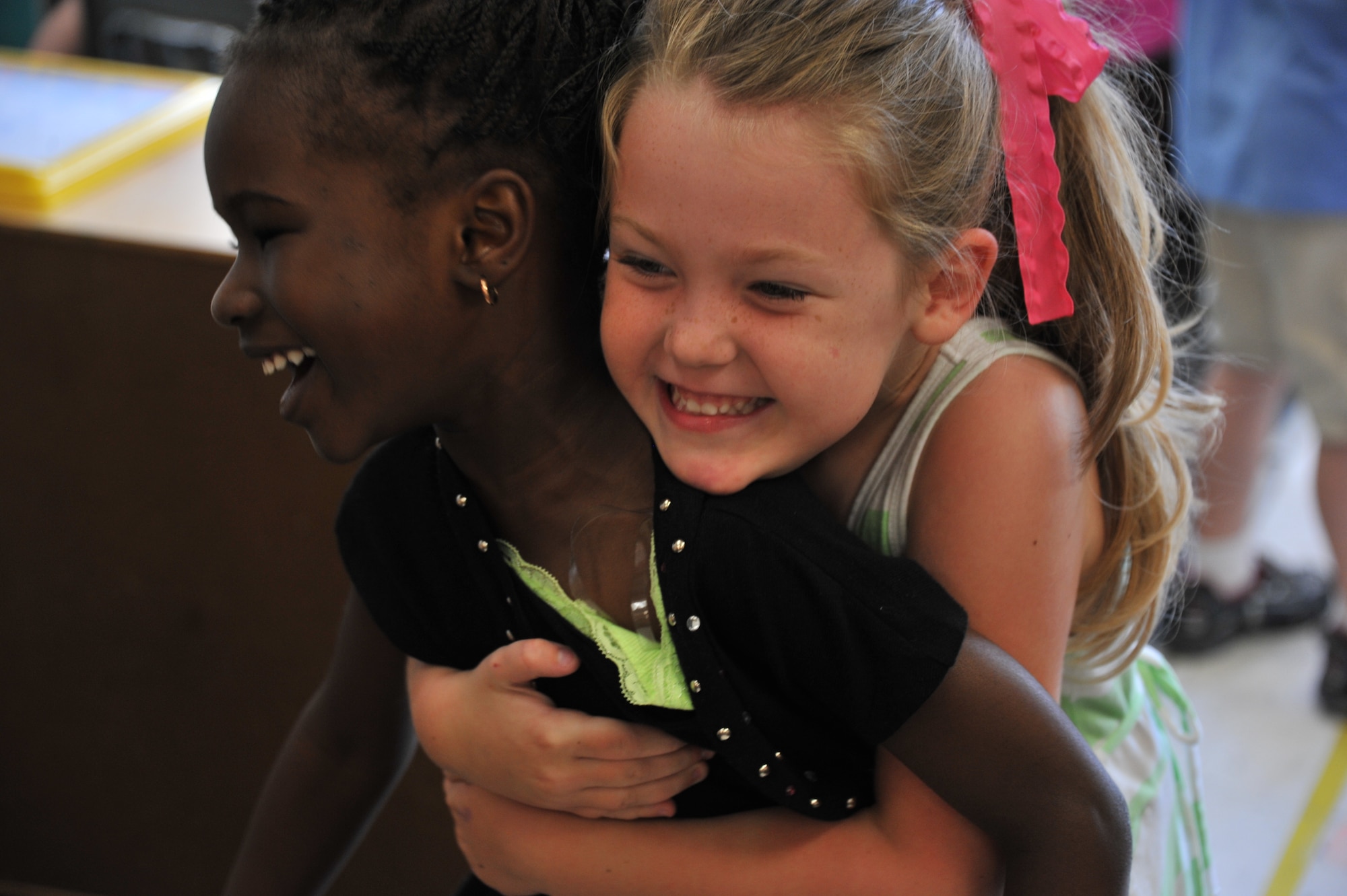 Sarah Caton, right, hugs her best friend Fatou Gueye at the Maxwell Air Force Base child development center, May 20, 2014. Both girls are 4-year-old students at the center. When Fatou, who is from Senegal, first arrived to the CDC she did not speak English, and was not familiar with American customs. Thanks to Sarah Fatou is now fluent in English and comfortable with cultural norms. (U.S. Air Force photo by Staff Sgt. Natasha Stannard)