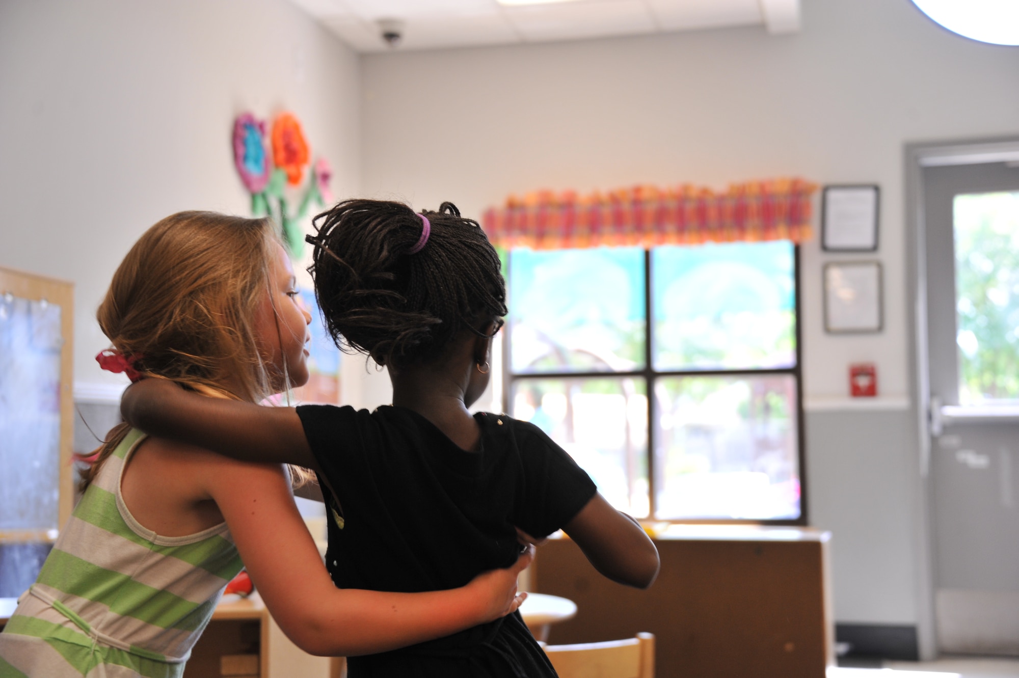 Sarah Caton, left, hugs her best friend Fatou Gueye, at the Maxwell Air Force Base child development center, May 20, 2014. Both girls are 4-year-old students at the center. When Fatou, who is from Senegal, first arrived to the CDC she did not speak English, and was unfamiliar with American customs. Thanks to Sarah, Fatou is now fluent in English and has adjusted to American practices. Many foreign students attend the Maxwell CDC as their parents go through officer schools at the Air University. (U.S. Air Force photo by Staff Sgt. Natasha Stannard)
