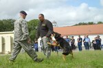 Staff Sgt. Michael Moore and decoy Technical Sgt. Michael Sengphradeth, 902nd Security Forces Squadron, and his dog Ramon demonstrate how dogs attack violators June 4, 2014 during the Critical Days of Summer event at Joint Base San Antonio-Randolph. (U.S. Air Force photo by Joel Martinez)