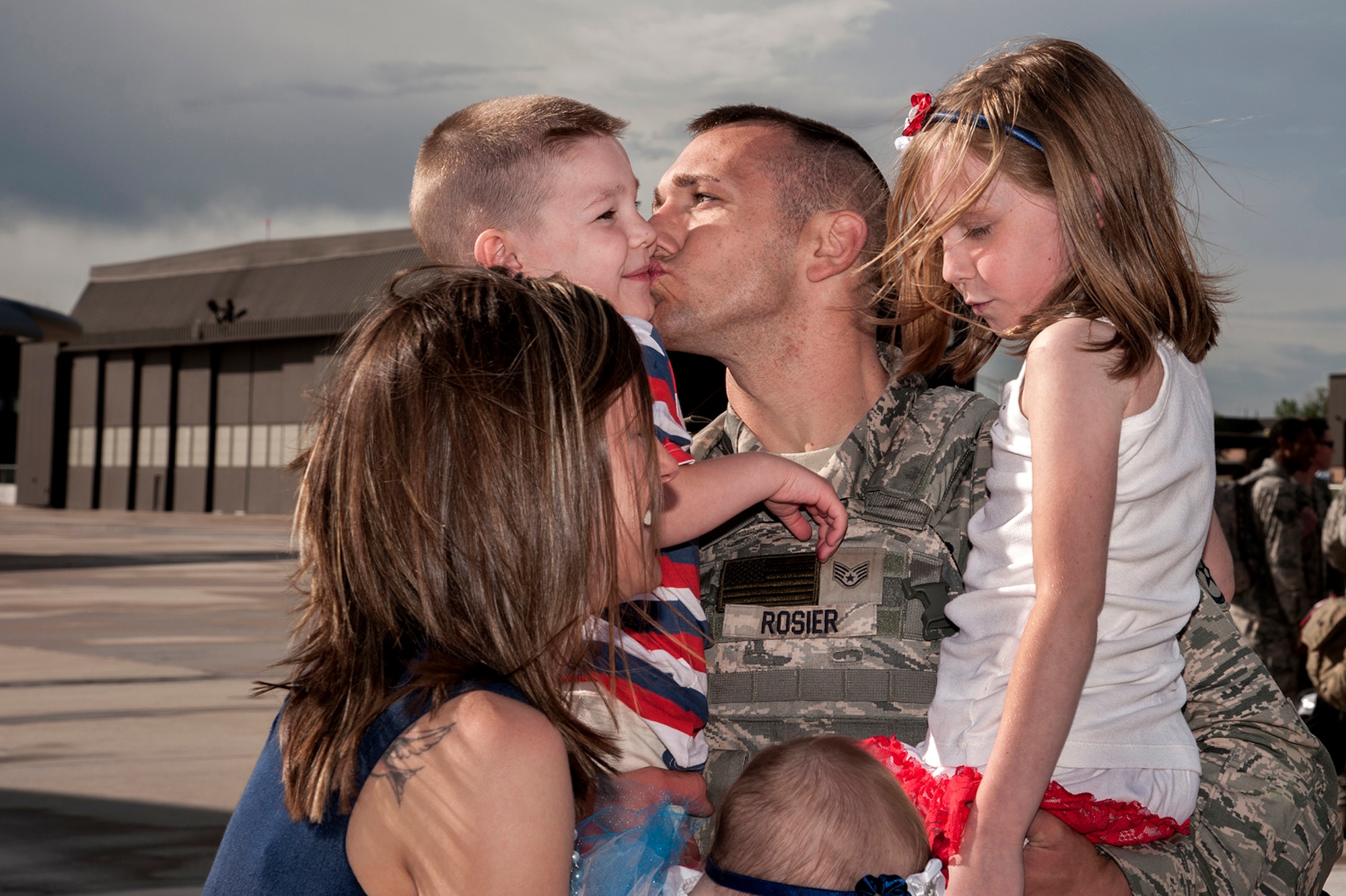 PETERSON AIR FORCE BASE, Colo. – Staff Sgt. Jared Rosier, 21st Security Forces Squadron, greets his family May 30 at the Peterson flight line. Rosier was part of a team of Airmen completing deployments to support space control operations with the 17th Expeditionary Space Control Squadron mission to Southwest Asia. (U.S. Air Force photo/Craig Denton)