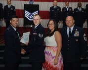Staff Sgt. Cody Neale, 2nd Security Forces Squadron, receives a certificate of promotion from Col. Andrew Gebara, 2nd Bomb Wing commander, and Chief Master Sgt. Stephen Lebrun, 2nd Operations Group, during the May Promotion Ceremony on Barksdale Air Force Base, La., May 30, 2014. (U.S. Air Force photo/Senior Airman Benjamin Gonsier)