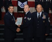 Staff Sgt. Tommy Lester, 2nd Security Forces Squadron, receives a certificate of promotion from Col. Andrew Gebara, 2nd Bomb Wing commander, and Chief Master Sgt. Stephen Lebrun, 2nd Operations Group, during the May Promotion Ceremony on Barksdale Air Force Base, La., May 30, 2014. (U.S. Air Force photo/Senior Airman Benjamin Gonsier)