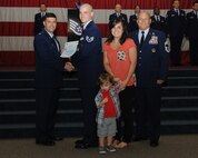 Staff Sgt. Corey Donelson, 2nd Security Forces Squadron, receives a certificate of promotion from Col. Andrew Gebara, 2nd Bomb Wing commander, and Chief Master Sgt. Stephen Lebrun, 2nd Operations Group, during the May Promotion Ceremony on Barksdale Air Force Base, La., May 30, 2014. (U.S. Air Force photo/Senior Airman Benjamin Gonsier)