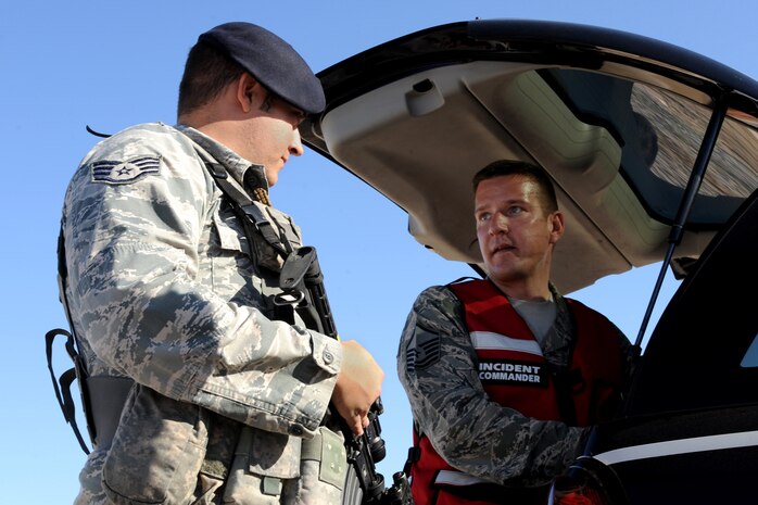 Staff Sgt. Jeremy Hogan, 99th Security Forces Squadron patrolman and Master Sgt. Michael Wobser, 99th Civil Engineer Squadron fire department assistant chief of operations discuss exercise scenario May 30, 2014 at Nellis Air Force Base. The exercise provided Airman the opportunity to get critical training for real-world situations such as aircraft mishaps and causalities. (U. S. Air Force photo by Airman 1st Class Monet Villacorte)