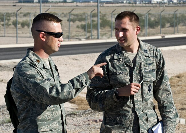 Maj. George Chapman, U.S.  Air Force Weapons School instructor, speaks to Capt. Michael Chetkowski, 315th Weapons Squadron weapons school student about aspects of the USAFWS integration exercise May 30, 2014, at Nellis Air Force Base, Nev. The exercise tests Airmen’s knowledge about their designated career field to help ensure they are always ready for real world scenarios. (U.S. Air Force photo by Senior Airman Jason Couillard)