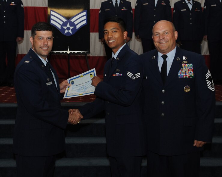 Senior Airman Andre Basay, 11th Bomb Squadron, receives a certificate of promotion from Col. Andrew Gebara, 2nd Bomb Wing commander, and Chief Master Sgt. Stephen Lebrun, 2nd Operations Group, during the May Promotion Ceremony on Barksdale Air Force Base, La., May 30, 2014. (U.S. Air Force photo/Senior Airman Benjamin Gonsier)
