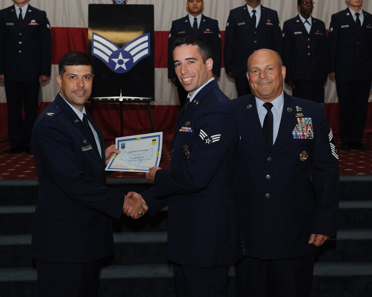 Senior Airman Michael Jacovsky, 2nd Security Forces Squadron, receives a certificate of promotion from Col. Andrew Gebara, 2nd Bomb Wing commander, and Chief Master Sgt. Stephen Lebrun, 2nd Operations Group, during the May Promotion Ceremony on Barksdale Air Force Base, La., May 30, 2014. (U.S. Air Force photo/Senior Airman Benjamin Gonsier)
