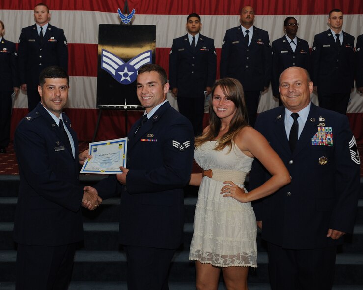 Senior Airman Austin Smith, 2nd Maintenance Squadron, receives a certificate of promotion from Col. Andrew Gebara, 2nd Bomb Wing commander, and Chief Master Sgt. Stephen Lebrun, 2nd Operations Group, during the May Promotion Ceremony on Barksdale Air Force Base, La., May 30, 2014. (U.S. Air Force photo/Senior Airman Benjamin Gonsier)