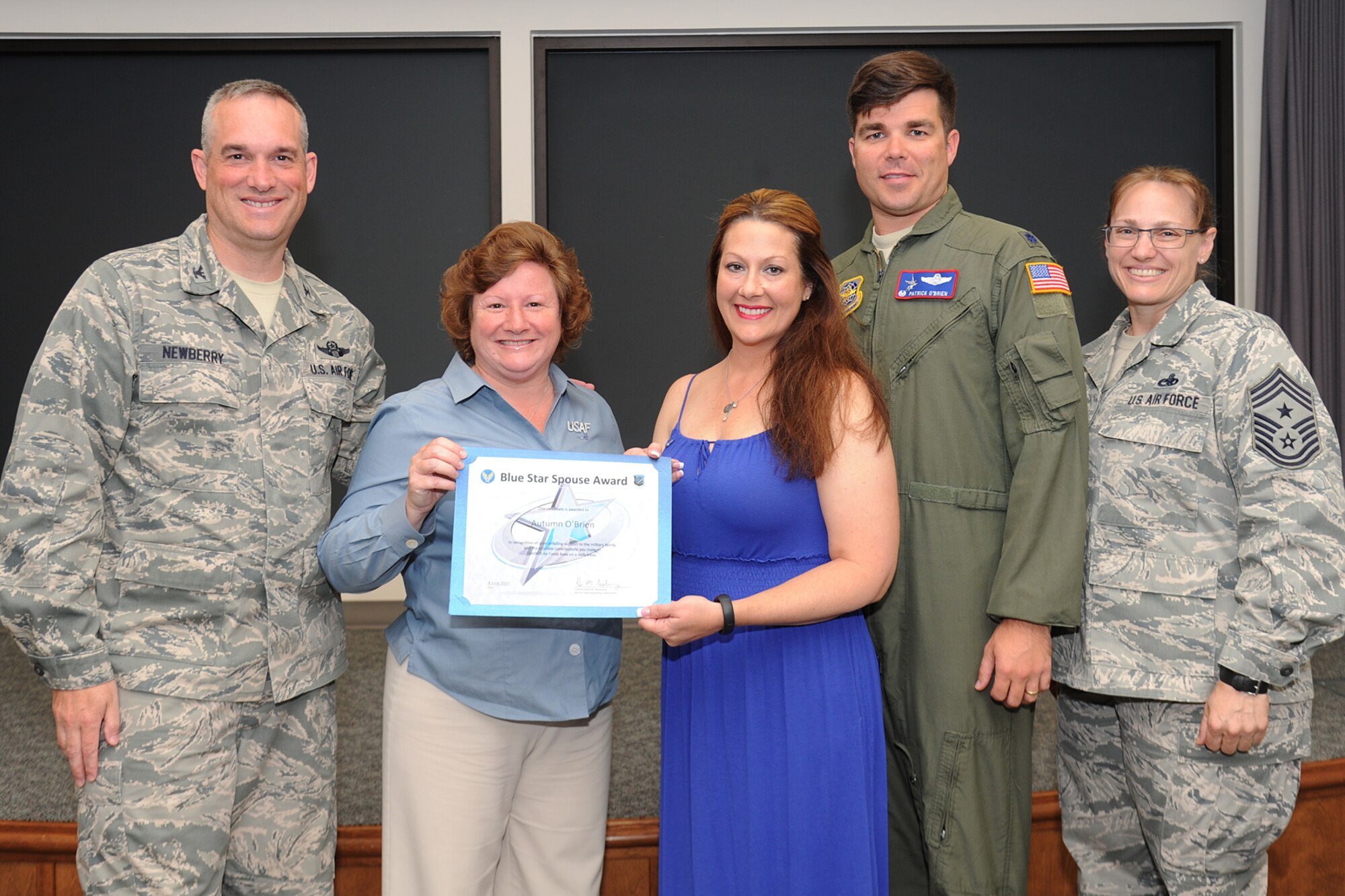 Col. Brian Newberry, his wife, Jill, and Chief Master Sgt. Wendy Hansen present the Blue Star Spouse Award to Autumn O’Brien, wife of Lt. Col. Patrick O’Brien, at Fairchild Air Force Base, Wash., June 4, 2014. The award is presented to Fairchild spouses for their commitment to excellence and support to the Fairchild family. According to Newberry, Autumn's tireless support of her squadron Airmen and families during difficult times healed families and motivated others to succeed. She was an amazing wingman for her husband and his squadron. Anyone interested in nominating someone for the Blue Star Spouse Award should contact their squadron commander. Newberry is the 92nd Air Refueling Wing commander, Hansen is the 92nd ARW command chief and O’Brien is the 93rd Air Refueling Squadron commander. (U.S. Air Force photo by Airman 1st Class Janelle Patiño/Released)