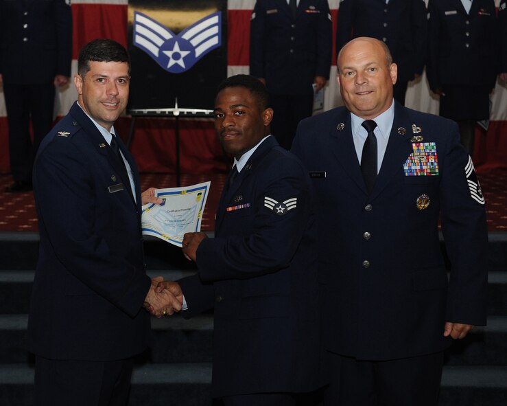 Senior Airman Jacoby McCormick, 2nd Maintenance Squadron, receives a certificate of promotion from Col. Andrew Gebara, 2nd Bomb Wing commander, and Chief Master Sgt. Stephen Lebrun, 2nd Operations Group, during the May Promotion Ceremony on Barksdale Air Force Base, La., May 30, 2014. (U.S. Air Force photo/Senior Airman Benjamin Gonsier)