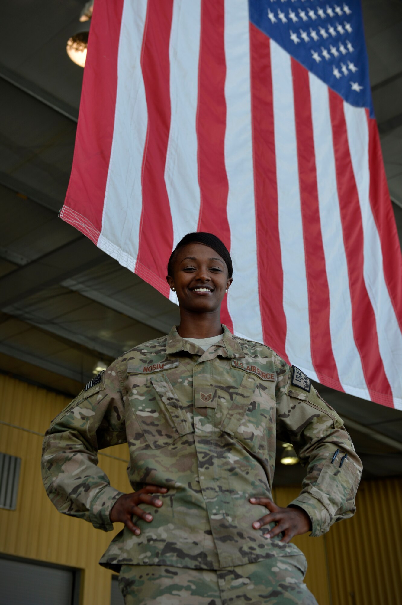 Staff Sgt. Lynette Nosim, 455th Expeditionary Logistics Readiness Squadron traffic management office receiving supervisor, poses for a photo in front of her squadron at Bagram Airfield, Afghanistan June 4, 2014.  Nosim volunteers at the Korean Vocational Training Center to help improve the student’s language skills. Nosim is deployed from McChord Air Force Base, Wash. and a native of Kennewick, Wash. (U.S. Air Force photo by Staff Sgt. Evelyn Chavez)