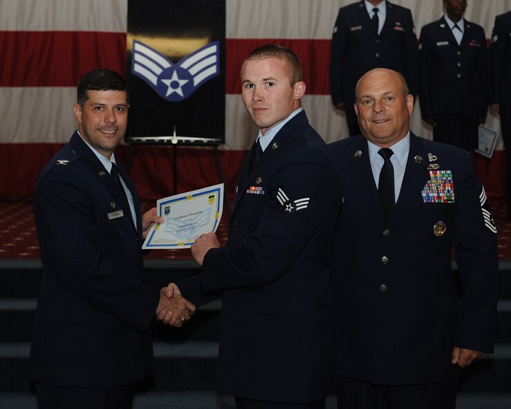 Senior Airman Harrison Shultz, 2nd Logistics Readiness Squadron, receives a certificate of promotion from Col. Andrew Gebara, 2nd Bomb Wing commander, and Chief Master Sgt. Stephen Lebrun, 2nd Operations Group, during the May Promotion Ceremony on Barksdale Air Force Base, La., May 30, 2014. (U.S. Air Force photo/Senior Airman Benjamin Gonsier)