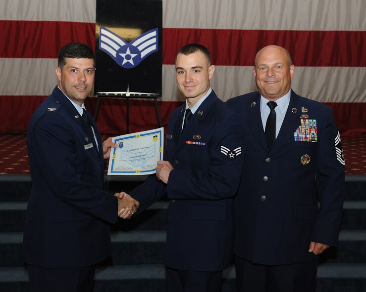 Senior Airman Brandon Boudreau, 2nd Contracting Squadron, receives a certificate of promotion from Col. Andrew Gebara, 2nd Bomb Wing commander, and Chief Master Sgt. Stephen Lebrun, 2nd Operations Group, during the May Promotion Ceremony on Barksdale Air Force Base, La., May 30, 2014. (U.S. Air Force photo/Senior Airman Benjamin Gonsier)