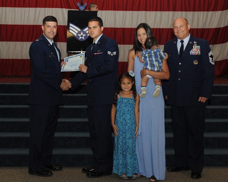 Senior Airman Rafael Paid Gonzalez, 2nd Aircraft Maintenance Squadron, receives a certificate of promotion from Col. Andrew Gebara, 2nd Bomb Wing commander, and Chief Master Sgt. Stephen Lebrun, 2nd Operations Group, during the May Promotion Ceremony on Barksdale Air Force Base, La., May 30, 2014. (U.S. Air Force photo/Senior Airman Benjamin Gonsier)