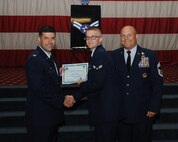Airman 1st Class Christopher Mourton, 2nd Maintenance Squadron, receives a certificate of promotion from Col. Andrew Gebara, 2nd Bomb Wing commander, and Chief Master Sgt. Stephen Lebrun, 2nd Operations Group, during the May Promotion Ceremony on Barksdale Air Force Base, La., May 30, 2014. (U.S. Air Force photo/Senior Airman Benjamin Gonsier)