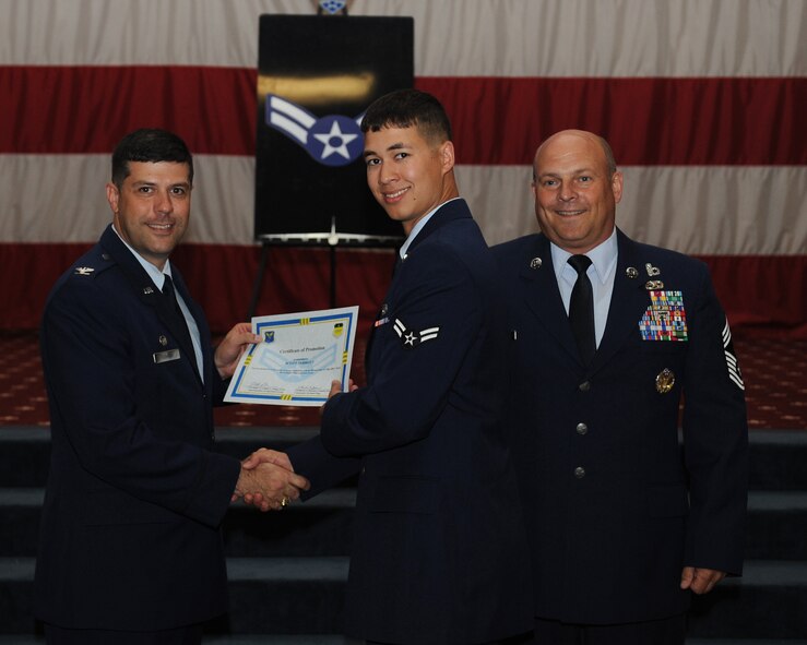 Airman 1st Class Scott Jarrott, 2nd Maintenance Squadron, receives a certificate of promotion from Col. Andrew Gebara, 2nd Bomb Wing commander, and Chief Master Sgt. Stephen Lebrun, 2nd Operations Group, during the May Promotion Ceremony on Barksdale Air Force Base, La., May 30, 2014. (U.S. Air Force photo/Senior Airman Benjamin Gonsier)