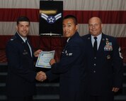 Airman 1st Class Khoi Pham, 2nd Civil Engineer Squadron, receives a certificate of promotion from Col. Andrew Gebara, 2nd Bomb Wing commander, and Chief Master Sgt. Stephen Lebrun, 2nd Operations Group, during the May Promotion Ceremony on Barksdale Air Force Base, La., May 30, 2014. (U.S. Air Force photo/Senior Airman Benjamin Gonsier)