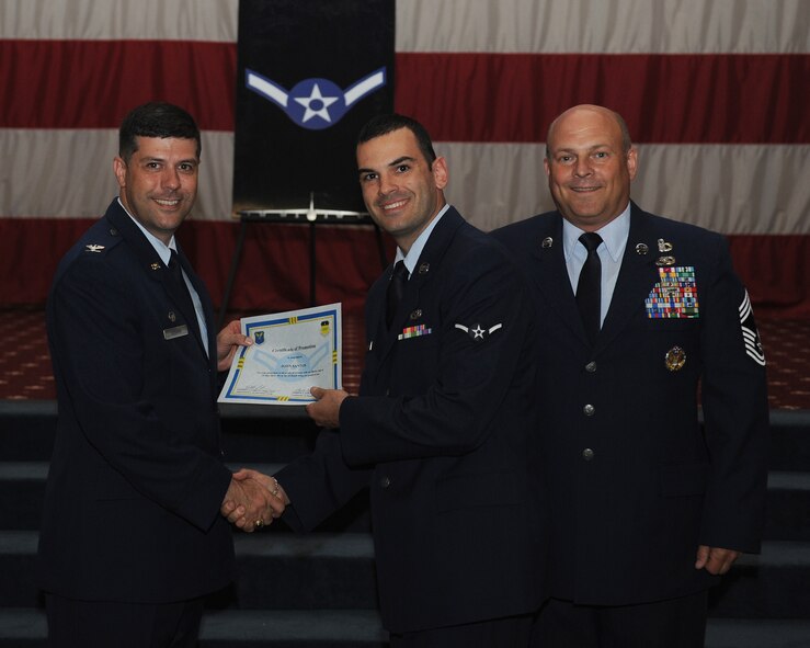 Airman John Santos, 2nd Munitions Squadron, receives a certificate of promotion from Col. Andrew Gebara, 2nd Bomb Wing commander, and Chief Master Sgt. Stephen Lebrun, 2nd Operations Group, during the May Promotion Ceremony on Barksdale Air Force Base, La., May 30, 2014. (U.S. Air Force photo/Senior Airman Benjamin Gonsier)