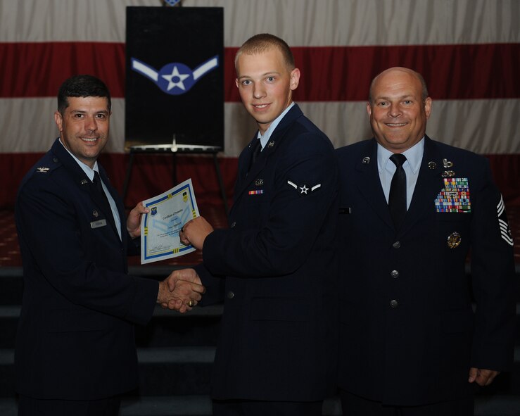 Airman Jake Pederson, 2nd Munitions Squadron, receives a certificate of promotion from Col. Andrew Gebara, 2nd Bomb Wing commander, and Chief Master Sgt. Stephen Lebrun, 2nd Operations Group, during the May Promotion Ceremony on Barksdale Air Force Base, La., May 30, 2014. (U.S. Air Force photo/Senior Airman Benjamin Gonsier)