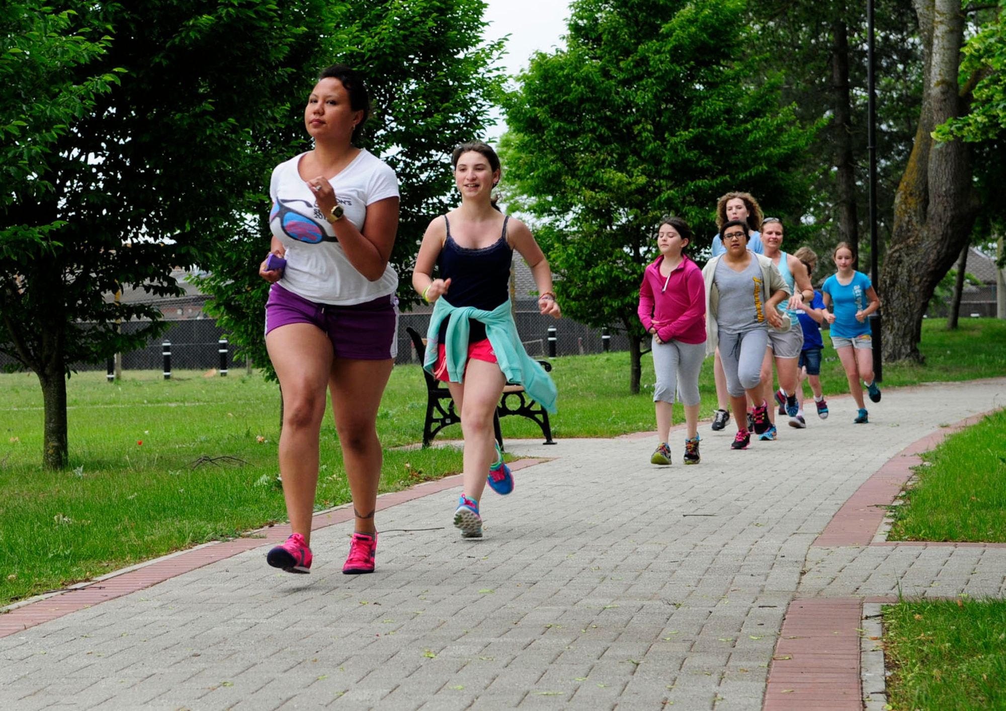 Tricia Wolanin, left, 321st Special Tactics Squadron contractor from Massilon, Ohio, leads a group of girls age 9 to 12 in a run as part of the “Girls on the Go!” club May 20, 2014, on RAF Mildenhall, England. The RAF Mildenhall Youth Center currently has a running program for youths, “Boys and Girls on the Go!,” which is divided into two separate groups for girls and boys. The goal of the program is to promote fitness and social-emotional development, and build healthy relationships. (U.S. Air Force photo/Karen Abeyasekere/Released)