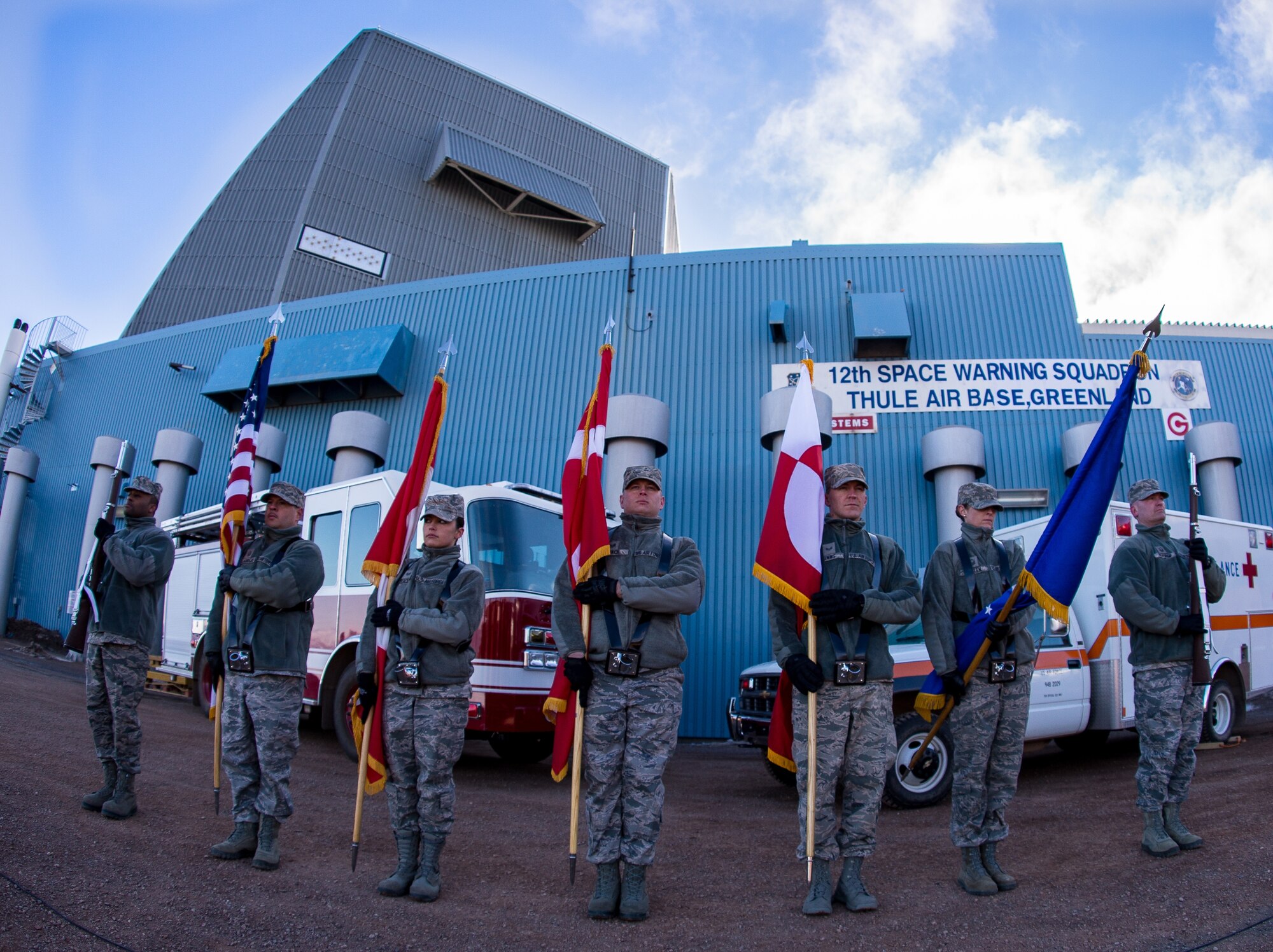 THULE AIR BASE, Greenland -- Ceremonial Guardsmen from the Top of the World Honor Guard present the American, Canadian, Danish and Greenlandic flags prior to the Memorial Day Array-to-the-Bay Relay Run hosted by the 12th Space Warning Squadron here May 25. The run was held to honor Airman 1st Class Matthew Seidler and Capt. David Lyon, two fallen service members from the 21st Space Wing at Peterson Air Force Base, Colo. (Courtesy photo/Torben Bjerre)