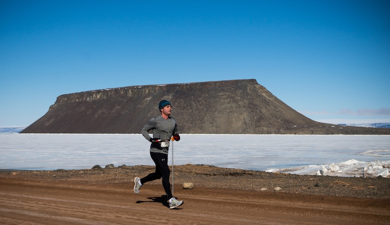 THULE AIR BASE, Greenland – Royal Canadian Air Force Master Corporal Gregory Janes, 12th Space Warning Squadron, heads for the finish line as he passes Mount Dundas along the Arctic Ocean during the Memorial Day Array-to-the-Bay Relay Run here May 25. Janes led the 12th SWS to victory during the event that honored two 21st Space Wing Airmen, Capt. David Lyon and Airman 1st Class Matthew Seidler, who were killed in action in Afghanistan. (Courtesy photo/Torben Bjerre)