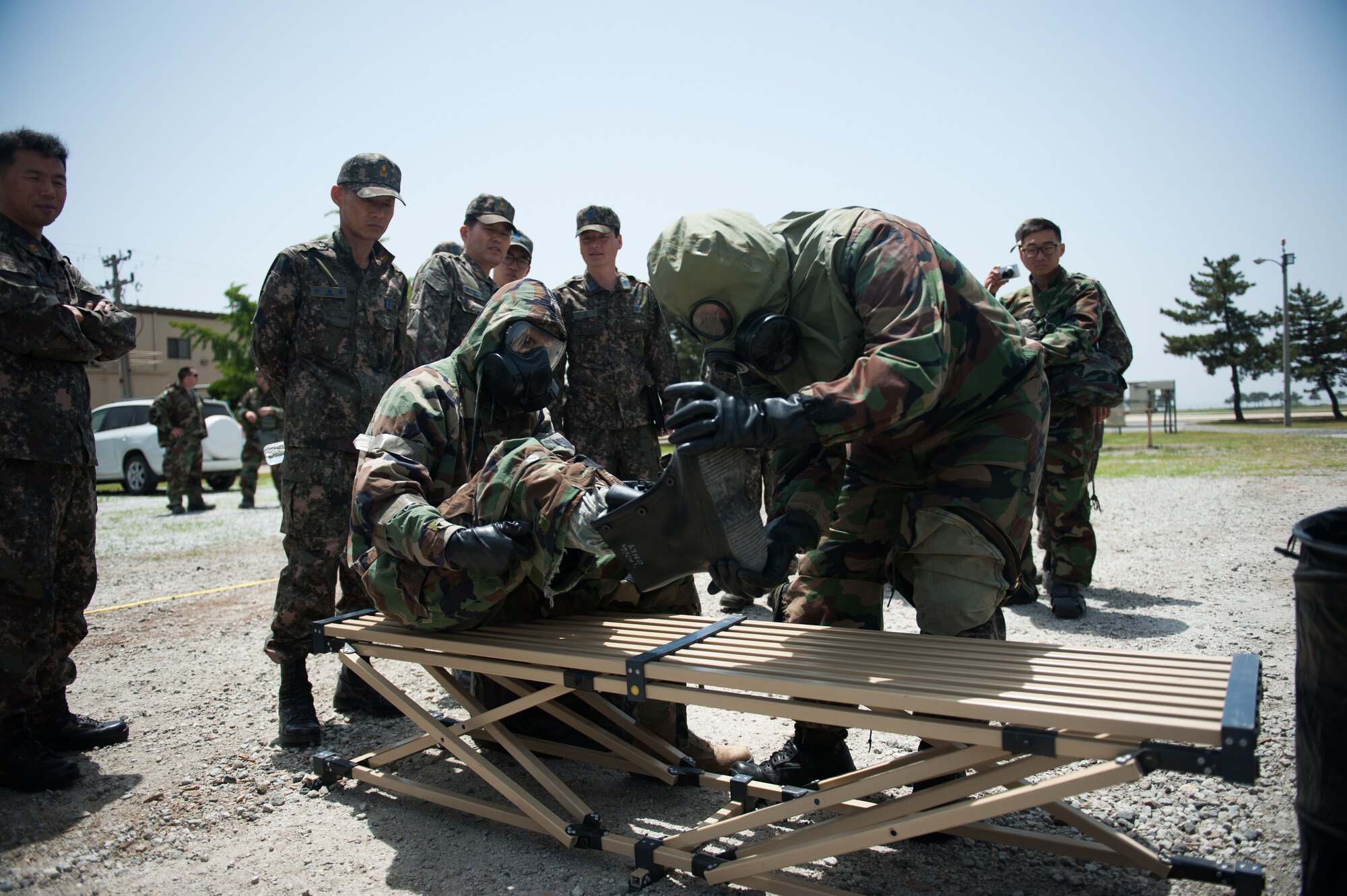 Staff Sgt. Jon Andrew, 8th Medical Operations Squadron bioenvironmental technician, and a Republic of Korea Airman remove their overboots while processing through a contamination control area during a combined exercise at Kunsan Air Base, Republic of Korea, May 28, 2014. This exercise tested the response of the Wolf Pack and RoKaf to a chemical threat. (U.S. Air Force photo by Staff Sgt. Clayton Lenhardt/Released)