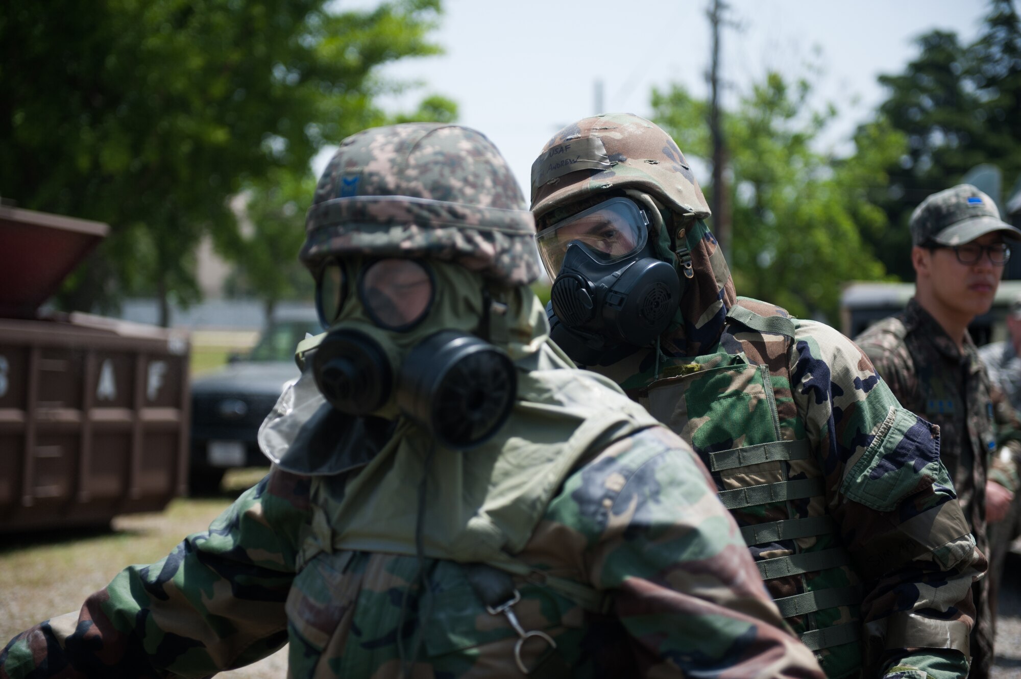 Staff Sgt. Jon Andrew, 8th Medical Operations Squadron bioenvironmental technician, and a Republic of Korea Airman use an M295 Individual Equipment Decontamination Kit while processing through a contamination control area during a combined exercise at Kunsan Air Base, Republic of Korea, May 28, 2014. This exercise tested the response of the Wolf Pack and RoKaf to a chemical threat. (U.S. Air Force photo by Staff Sgt. Clayton Lenhardt/Released)