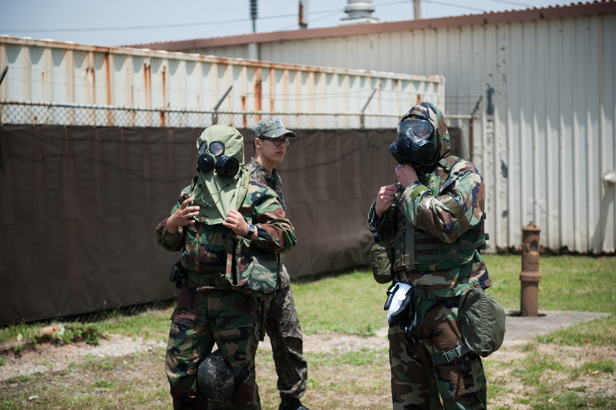 Staff Sgt. Jon Andrew, 8th Medical Operations Squadron bioenvironmental technician, and a Republic of Korea air force Airman don their protective gear during a combined exercise at Kunsan Air Base, Republic of Korea, May 28, 2014. This exercise tested the response of the Wolf Pack and RoKaf to a chemical threat. (U.S. Air Force photo by Staff Sgt. Clayton Lenhardt/Released)