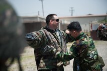 Tech. Sgt. Michael Osburn, 8th Civil Engineer Squadron emergency management training NCOIC, and a Republic of Korea Airman demonstrate how to use an M295 Individual Equipment Decontamination Kit during a combined exercise at Kunsan Air Base, Republic of Korea, May 28, 2014. This exercise tested the response of the Wolf Pack and RoKaf to a chemical threat. (U.S. Air Force photo by Staff Sgt. Clayton Lenhardt/Released)