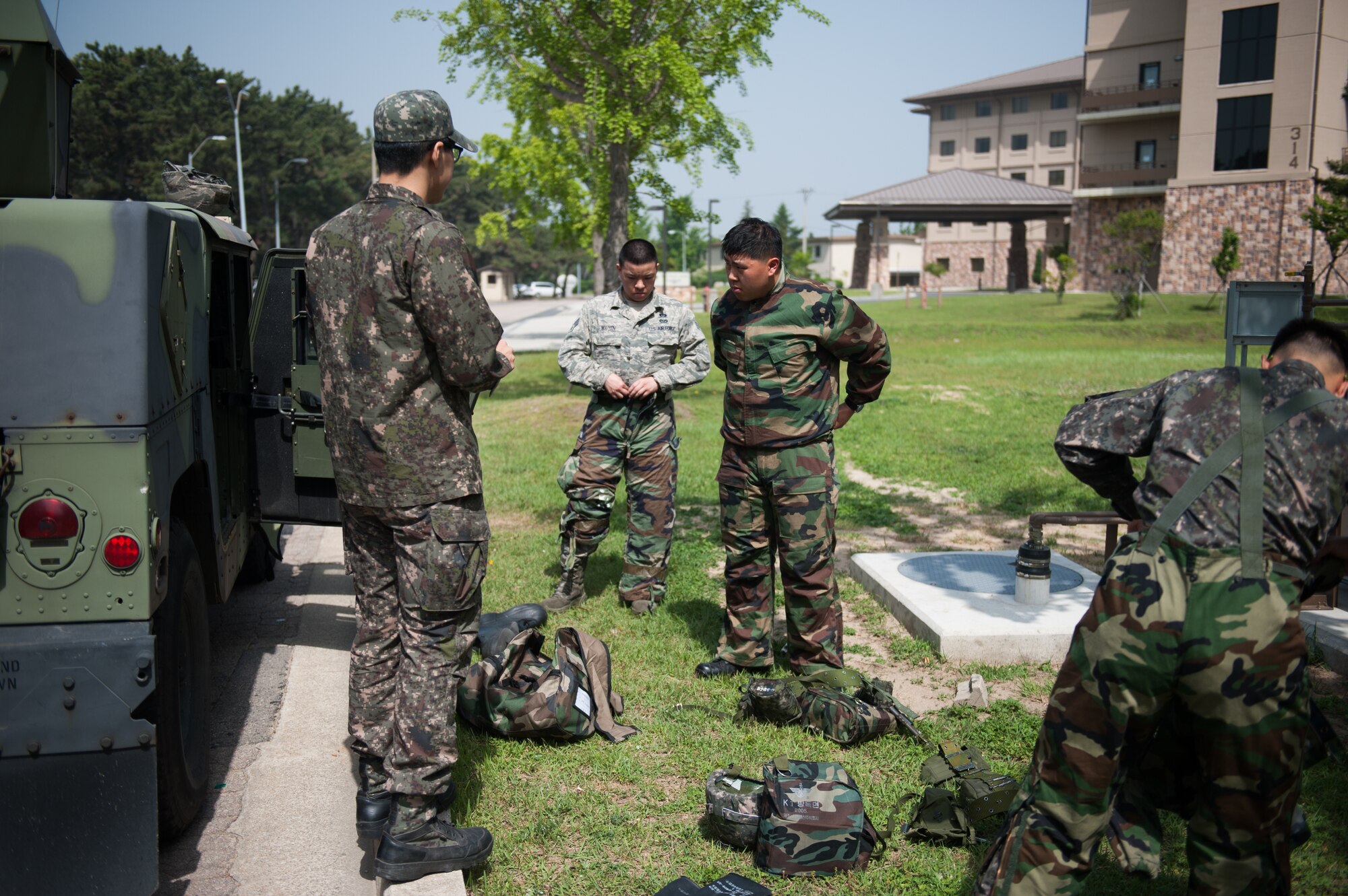Airmen from the 8th Civil Engineer Squadron and Republic of Korea air force don their protective gear during a combined exercise at Kunsan Air Base, Republic of Korea, May 28, 2014. This exercise tested the response of the Wolf Pack and RoKaf to a chemical threat. (U.S. Air Force photo by Staff Sgt. Clayton Lenhardt/Released)