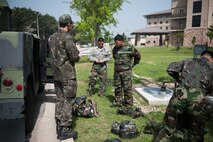 Airmen from the 8th Civil Engineer Squadron and Republic of Korea air force don their protective gear during a combined exercise at Kunsan Air Base, Republic of Korea, May 28, 2014. This exercise tested the response of the Wolf Pack and RoKaf to a chemical threat. (U.S. Air Force photo by Staff Sgt. Clayton Lenhardt/Released)
