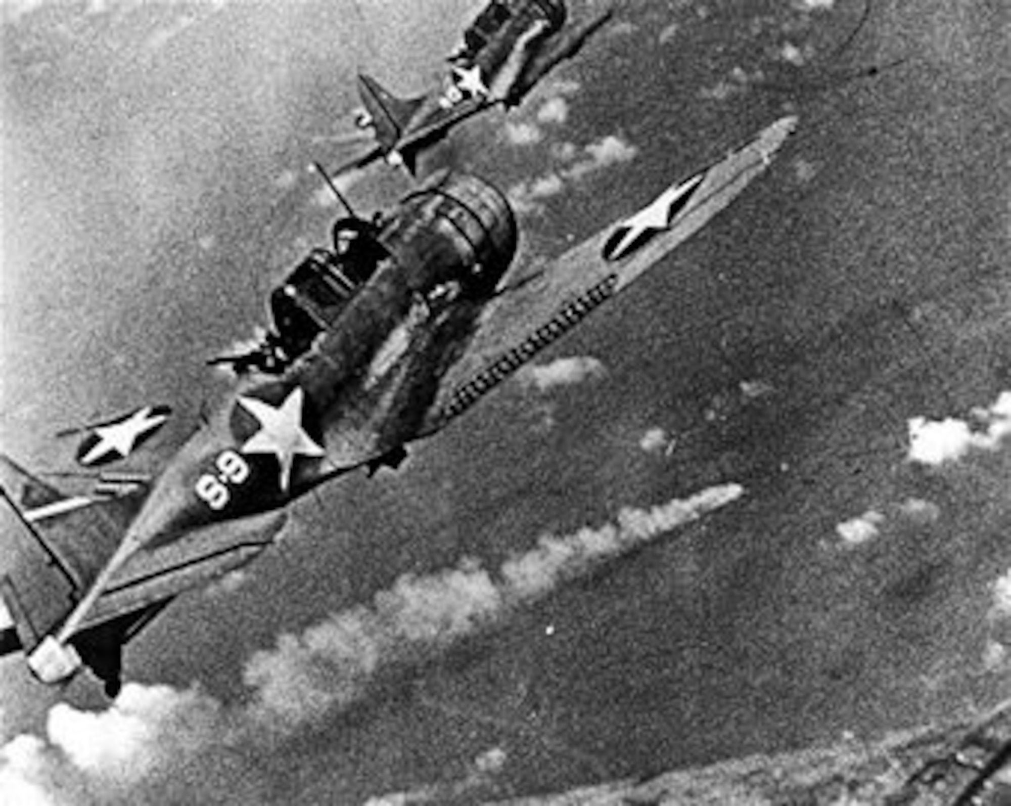 U.S. Navy SBD Dauntless dive bombers approach the burning Japanese heavy cruiser Mikuma for a third round of attacks near Midway Island, June 6, 1942.  Mikuma was one of five Japanese ships destroyed in the Battle of Midway along with approximately 292 Japanese aircraft.  (U.S. Navy photo courtesy of the National Archives Collection)    