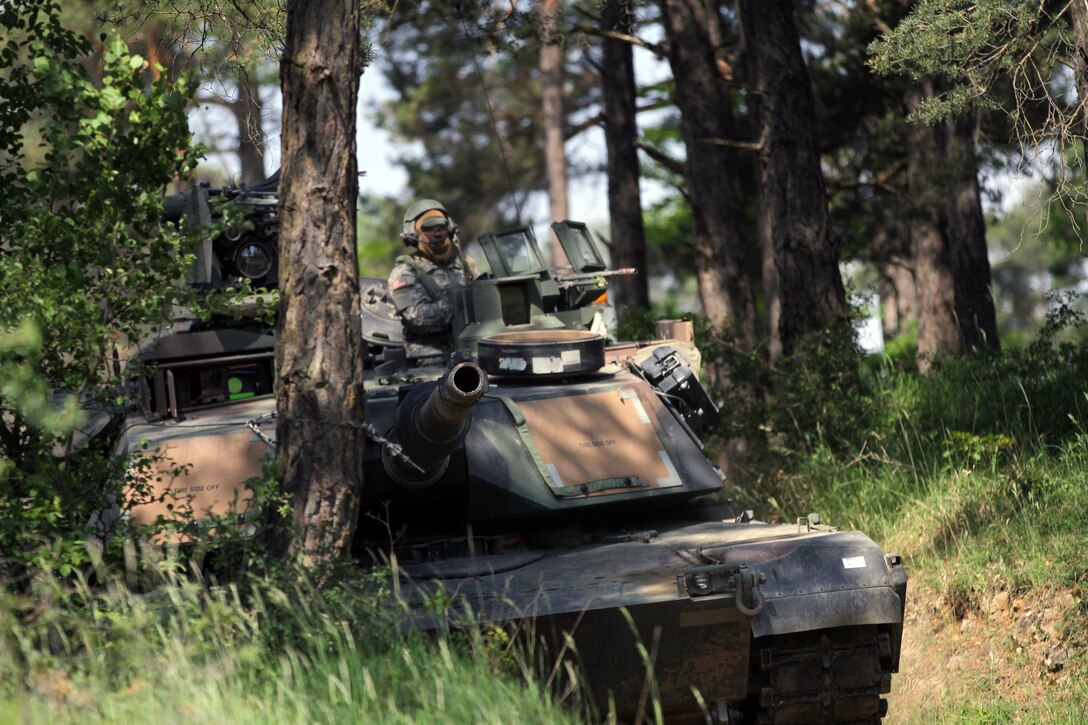 U.S. soldiers scan their sector from the gunners turret on a M1A1 Abrams tank for the opposing forces during Exercise Combined Resolve II at the Joint Multinational Readiness Center in Hohenfels, Germany, May 26, 2014.
