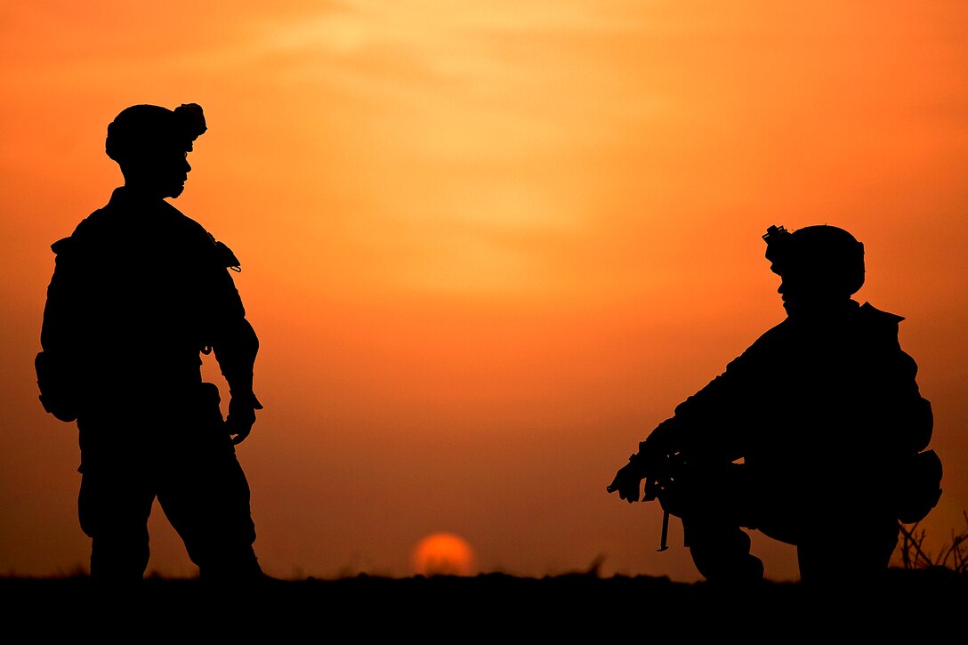 U.S. Marine Lance Cpls. Ryan Snyder and David Lambert talk while providing security from their defensive position as the sun sets during Operation Shahem Tofan Eagle Storm in the Garmsir district, Helmand province, Afghanistan, Feb. 11, 2012. Snyder and Lambert are assigned to Weapons Company, 3rd Battalion, 3rd Marine Regiment.  
