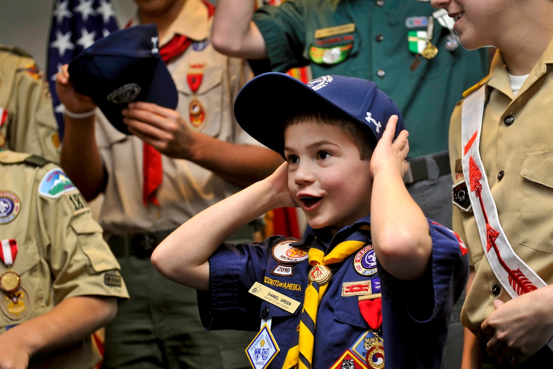 Cub Scout Daniel Logan Green, 8, reacts with excitement as he receives a Defense Department ball cap from Defense Secretary Leon E. Panetta at the Pentagon, Feb. 13, 2012. Green and a delegation of Boy Scouts gave Panetta a copy of the annual report for the Boy Scouts of America during their visit.  
