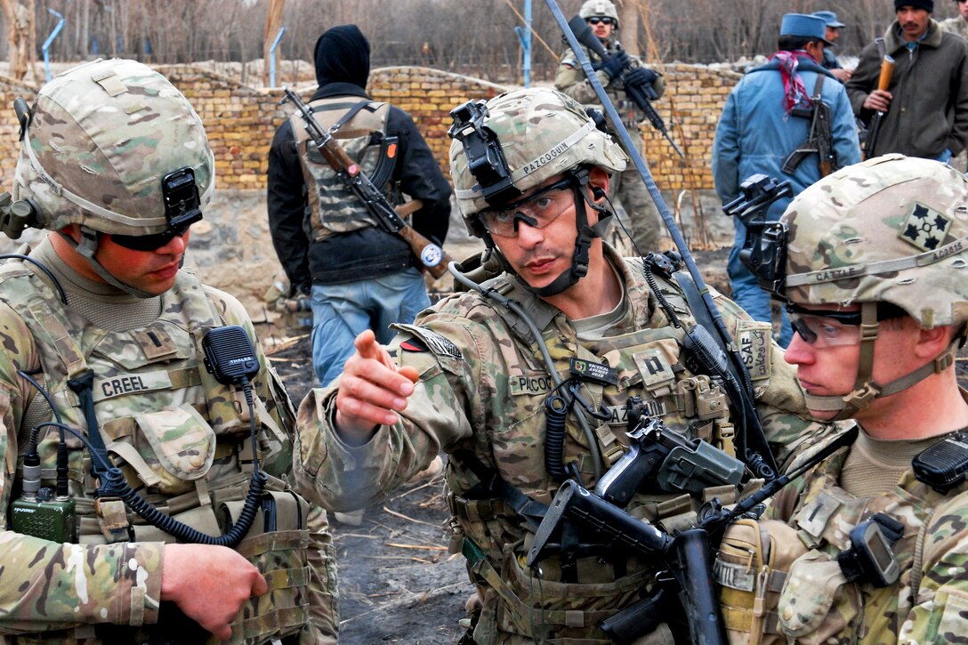 U.S. Army Capt. Joe Pazcoguin, center, talks with 1st Lt. Austin Cattle, right, and 1st Lt. Mitchell Creel during a clearance operation in western Kandahar, Afghanistan, Feb. 1, 2012. Pazcoguin is the commander of the 4th Infantry Division's Company B, 1st Battalion, 67th Armor Regiment, 2nd Brigade Combat Team. Cattle is assigned to Company B and Creel is assigned to the 530th Engineer Company.  
