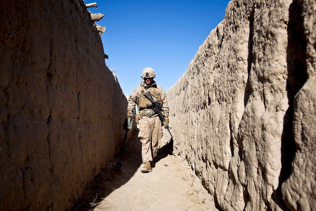 U.S. Marine Cpl. Cameron Collier sweeps an alley during a security patrol in the Garmsir district in Afghanistan's Helmand province, Feb. 6, 2012. Collier is a combat engineer assigned to Weapons Company, 3rd Battalion, 3rd Marine Regiment. Marines from his unit and Afghan soldiers partnered to conduct census operations, and search houses for illegal drugs and evidence of insurgent activity.  
